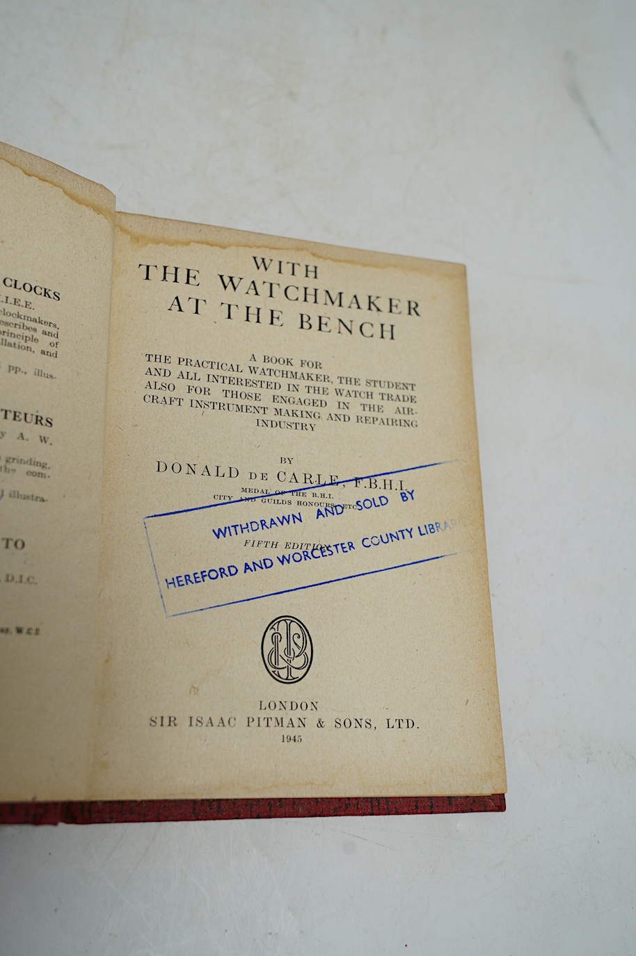 A collection of watch parts, tools and a small selection of costume jewellery, housed in two cases, together with two books. Condition - poor to fair